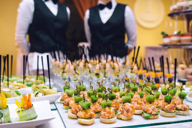 Catering table of canapes with two servers in background